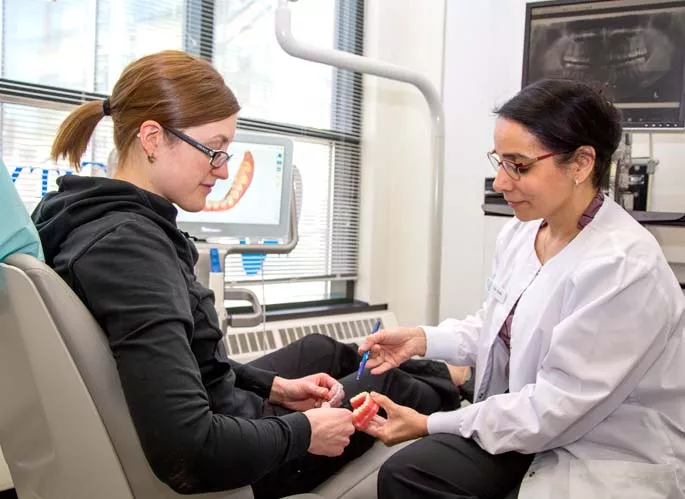 Dr. Soin using tooth model to explain procedure